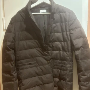 Brun kavajacka från These Glory Days - Säljer en stilren brun quiltad kavaj från These Glory Days i storlek medium. Perfekt för höst och vinter med sin varma och eleganta design. Kavajen har långa ärmar och stängs med knappar framtill. Passar både till vardags och festliga tillfällen. 