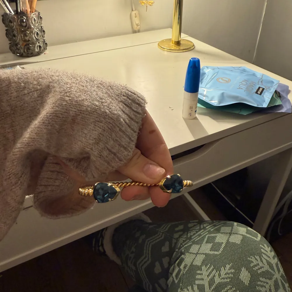 Säljer ett elegant guldarmband från Caroline Svedbom med två stora blå stenar 🩵. Accessoarer.