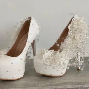 Vita pumps med pärlor och blommor - Superfina vita pumps med hög klack, dekorerade med pärlor och blommor. Perfekta för bal eller bröllop! De har en spetsig tå och är riktigt eleganta med sina detaljer. Passar perfekt för en speciell kväll.