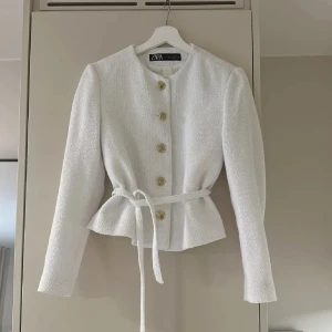 Vit kavaj från Zara - Säljer den populära kavajen/koftan från Zara i mycket bra skick. Aldrig använd och snöret går att ta på/av när man vill. Storlek M men är mer som S/M. Nypris: 700kr 