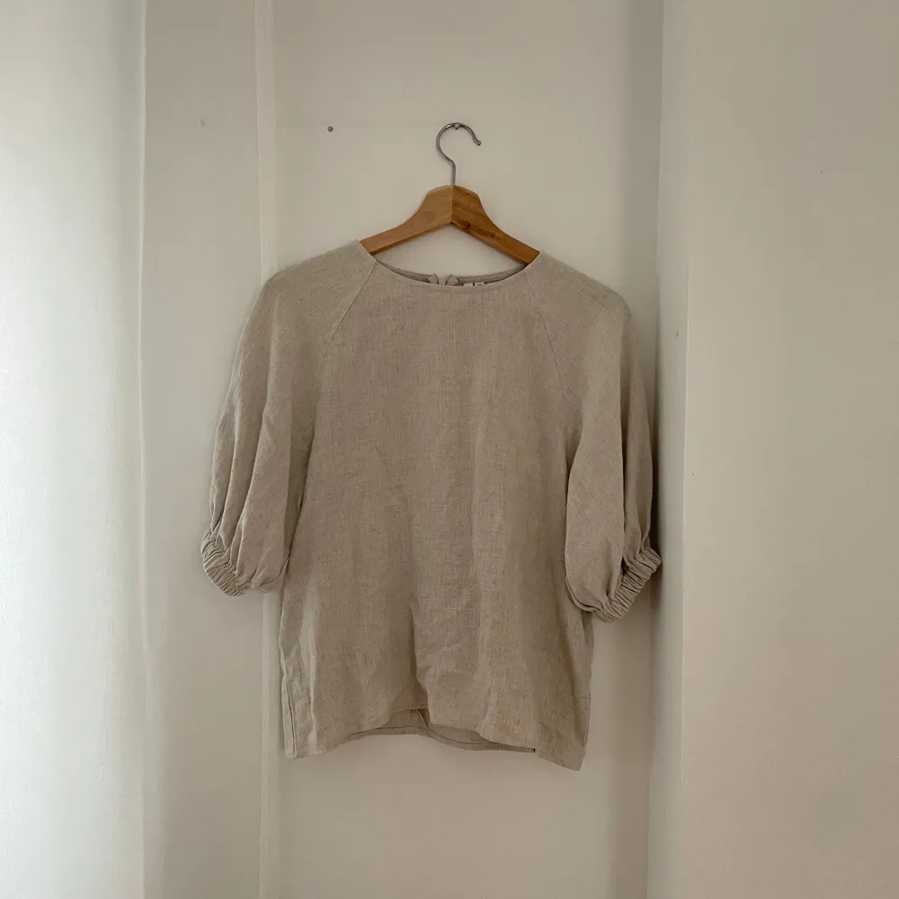 Säljer en stilren beige blus från NLY Trend i storlek 34. Blusen har trekvartsärmar med en lätt puffig design och en diskret dragkedja i ryggen. Perfekt för både vardag och festliga tillfällen. 🥰. Toppar.