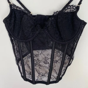 Svart spetskorsett - Snygg svart korsett i spets med justerbara axelband. Har använts 1 gång 💕passar perfekt till fest 🎈 