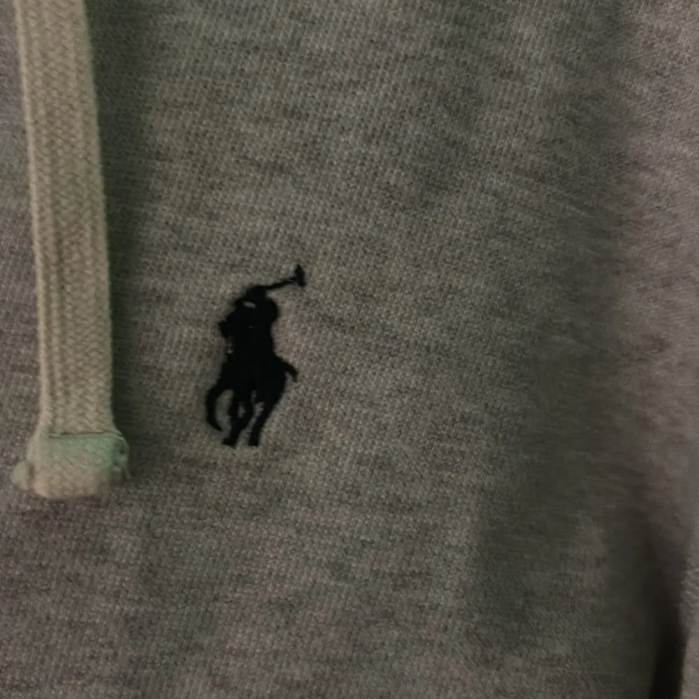 Säljer en snygg och bekväm grå hoodie från Ralph Lauren. Den har en dragkedja framtill och en klassisk logga på bröstet. Perfekt för en avslappnad stil och passar till alla årstider. Den är i bra skick och redo för nya äventyr!. Hoodies.