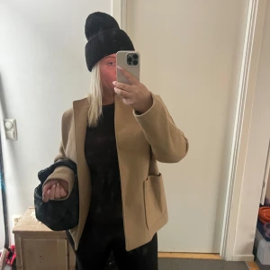 Beige kappa - Säljer en snygg beige kappa i mycket bra skick. Den har en stilren design med normal passform och långa ärmar. Perfekt för höst och vår! 🧥