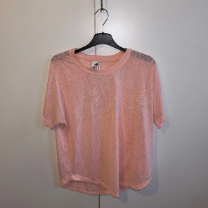 Rosa t-shirt från Adidas - Säljer en snygg rosa t-shirt från Adidas i storlek S. Den är gjord i ett lätt och luftigt material, perfekt för träning eller en avslappnad dag. T-shirten har korta ärmar och en diskret Adidas-logga på bröstet. Perfekt för dig som vill ha en sportig och bekväm stil! 🌸