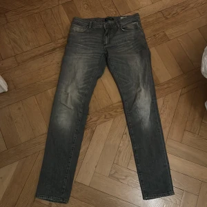 Grå jeans från Antony Morato - Säljer ett par grå skinny jeans från Antony Morato i bra skick. De har en snygg tvättad look och klassisk femficksdesign. Perfekta för både vardag och fest! Passar dig som gillar en tight passform.