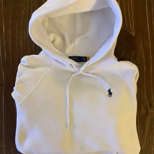 Säljer en snygg vit hoodie från Polo Ralph Lauren i storlek S. Den har en klassisk design med en liten broderad logga på bröstet och en praktisk känguruficka. Perfekt för både vardag och chill. Huvan har dragsko för justerbar passform. Superfräsch och i bra skick! Storlek S men sitter mer som en XS. Passar dig runt 170, neråt. Vid frågor ev funderingar, kom privat!!