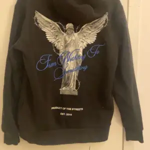 Säljer en svart hoodie från Hoodrich med en cool ängelgrafik och texten 'From Nothing To Something' i blått på ryggen. Framsidan har en mindre logga med samma tema. Passar perfekt till höst och vinter!