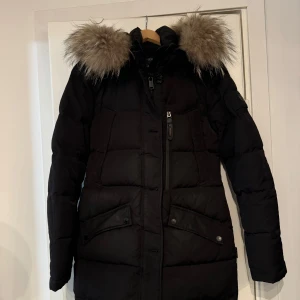 Svart Hollies Jacka med Äkta päls - Säljer en vattenavvisande med äkta päls i storlek 36. Har endast använt den en vinter så jackan är i nyskick. Nypriset på jackan idag ligger på 4495 kr. 💓 Jackan är varm och skön, men passar helt enkelt inte längre.