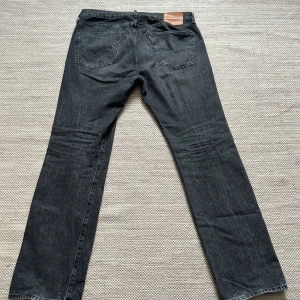 Svarta Levi's 501 jeans - Säljer ett par klassiska svarta Levi's 501 jeans i storlek W36 L32. De är i bra skick och gjorda av 100% bomull. Perfekta för både vardag och fest med sin tidlösa design och raka passform.