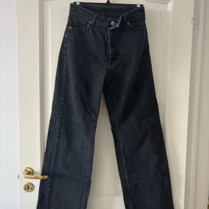 Svarta jeansbyxor - Säljer ett par svarta jeansbyxor i mycket bra skick. De har en högmidjad passform och en trendig wide stil, från Monki!