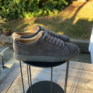 Gråa Myrqvist sneakers i mocka - Säljer ett par stilrena grå/svart sneakers i mocka. Knappt använda och skicket är 8,5/10 om inte bättre med en liten slitning på hälarna. Annars är dom i väldigt bra skick! Originalbox samt kvitto finns. Hör av er vid minsta lilla fråga / om ni vill ha fler bilder NYPRIS 2000kr
