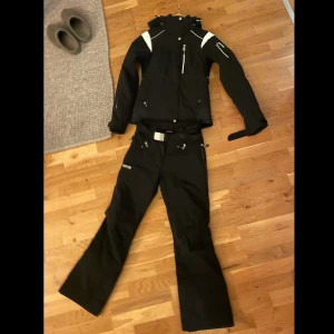 Skidställ 8848 - Fodrade skidkläder i jättebra skick, inga tecken på användning. Säljs ihop.  Byxorna har dragkedjefickor och ventialtionsfickor på sidorna.  Jackan har tre fickor fram, innerficka, liftkortsficka på vänster arm och ventilationsfickor på båda sidor.