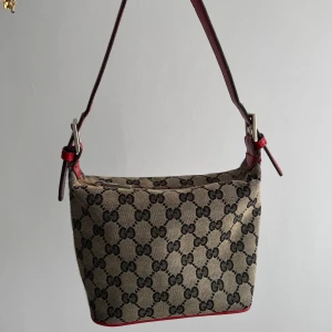 Vintage väska  - Superfin vintage handväska med röda detaljer, då handväskan är köpt secondhand kan inte dess äkthet garanteras👜