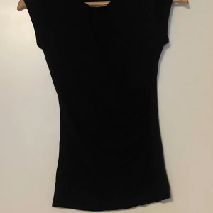 Svart topp med gulddetalj - Svart topp som inte kommer till användning 