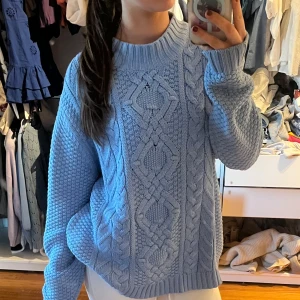 Ljusblå stickad tröja - Superfin ljusblå stickad tröja med snyggt flätmönster. Den är perfekt för kyliga dagar och har en skön, oversized passform. Tröjan har långa ärmar och en rund halsringning. Perfekt för både höst och vinter! 💙