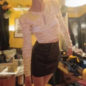 Vit satinblus - Säljer en elegant vit blus i satin. Blusen har långa ärmar och en snygg rynkad detalj framtill som ger en fin form. Perfekt för både fest och vardag! ✨