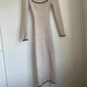 Stickad klänning med kontrastkanter - Beige klänning med svarta kontrastkanter i storlek XS.