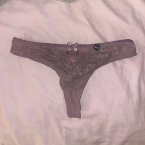 Hunkemöller trosor 💜 - Ett par helt nya stringtrosor från hunkemöller. Prislappen är kvar, är inte ens testade. Orginalpris 189kr. Färgen är som en smutslila med glitter💜