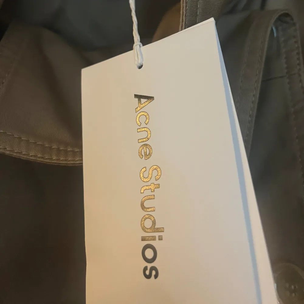 Helt oanvänd trenchcoat från Acne Studios i nyskick med lappen kvar. Storlek 42 (M) men passar också S. Originalpris: 6000kr Pris kan diskuteras!. Jackor.