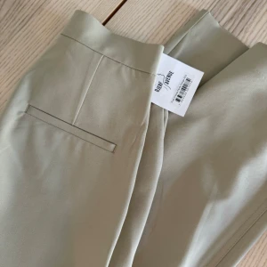 First choice pants Djerf Avenue  - Säljer ett par oanvända kostymbyxor från Djerf Avenue i storlek XXS. Modellen är ”First Choice Pants” och i färgen greige. Säljes då de tyvärr inte kommer till användning. Passar mig som i de flesta fall har storlek XS i byxor.