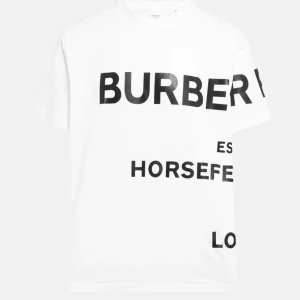 Vit t-shirt från Burberry - Säljer en stilren vit t-shirt från Burberry med svart texttryck. Den har en klassisk passform och är perfekt för en avslappnad look. Passar både till vardags och fest!