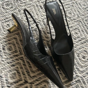 Spetsiga klackskor - Supersnygga svarta klackskor i läderimitation med spetsiga tår. De är kittenheels med en guldig snygg klack.🥰