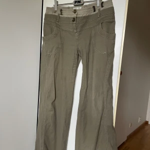 Bootcut byxor  - Tunna utåtsvängda byxor i stretchigt material. Lite slitna i läder detaljerna annat bra kvalitet. Insydda i midjan och uppsydda så skulle uppskatta storleken till S/36 till M/38. 