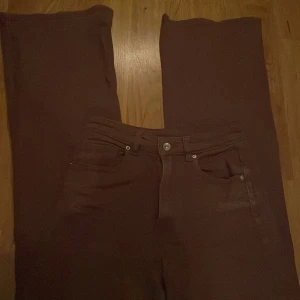 Bruna byxor från H&M Divided - Säljer ett par snygga bruna jeans från H&M Divided. De är i storlek EUR 36 och har en klassisk femficksdesign. Perfekta för både vardag och fest!