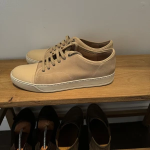Beige sneakers med snörning - Säljer ett par stilrena beige lanvin sneakers. Är som nya, knappt använda. Dustbag fås med. Storlek 46