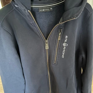 Sail racing hoodie - Säljer min sail racing hoodie i storlek 160 då jag vuxit ur den, använd ett par gånger o inga defekter. Nypris 1000kr