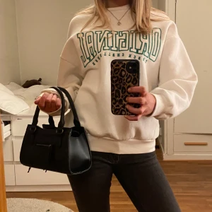 Sweatshirt - Säljer en vit sweatshirt med grönt tryck/broderi på framsidan ifrån Gina tricot. Tröjan har en avslappnad passform och långa ärmar. Den är gjord i ett mjukt material vilket gör den väldigt skön. Knappt använd! Köpt snabbt och enkelt via ’köp nu’!💞