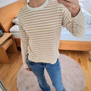 Beige och vit randig tröja från Monki - Beige och vit randig tröja från Monki i storlek XS. Tröjan har långa ärmar och en rund halsringning. Är 163 cm. Super tunnt och skönt tyg!🤍💛