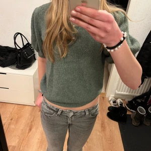Grön stickad tröja från Vero Moda - Säljer en mysig grön stickad tröja från Vero Moda. Tröjan har korta puffiga ärmar och en rund halsringning. Tröjan är i storlek M men passar även fler storlekar💘 Använd men har inga defekter 