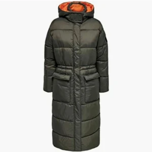 Grön lång pufferjacka från ONLY - Säljer en grön lång pufferjacka från ONLY med orange foder. Jackan har en huva och långa ärmar, perfekt för kalla dagar. Den har en dragkedja framtill och praktiska fickor. En stilren och varm jacka för vintern. Jackan är vadlång. Endast använd några få gånger. Ett litet hål på vänstra arm knappt synlig. Inköpspris 899kr.