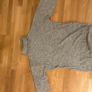 Grå polotröja från H&M - Säljer en stilren grå polotröja från H&M. Den har långa ärmar och en klassisk polokrage. 