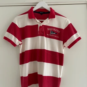 Röd och vit randig pikétröja från GANT - Säljer en snygg röd och vit randig pikétröja från GANT. 