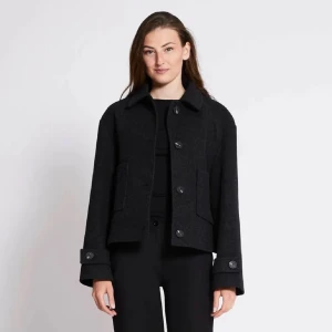 Svart kappa med knappar - Snygg svart kappa med knappar framtill och klassisk krage. Jackan har långa ärmar och praktiska fickor. Perfekt för kyligare dagar och ger en stilren look.