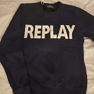 Mörkblå sweatshirt från Replay - Säljer en snygg mörkblå sweatshirt från Replay med stort vitt tryck på framsidan. Tröjan har långa ärmar och rund halsringning.   Storlek S