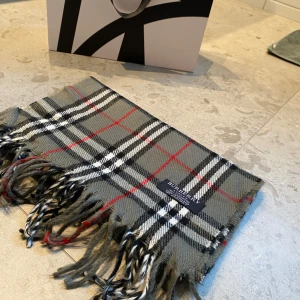 Burberry halsduk  - Hej, nu säljer jag en burberry scarf perfekt skick inga tydliga defekter på användning. Den är äkta men inget kvitto eller något följer med tyvärr. Halsduken är i materialet: 100% Kashmir. Normal i storleken och passar perfekt till alla. Pris går att diskutera vid snabb affär. Skriv till mig vid minsta lilla funderingen 😊, Mvh