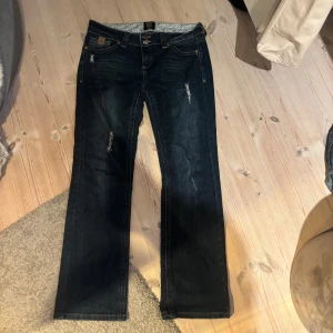Mörkblåa jeans från Blind Date - Snygga mörkblå jeans från Blind Date med en bootcut-stil. De har en lågmidjad passform och slitna detaljer för en trendig look. Perfekta för en avslappnad stil. Det står ingen storlek men skulle säga att de sitter som S/M 💗dm mig för mått osv.💕