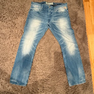 Replay jeans slim fit - Snygga ljusblå slim fit jeans från Replay med en klassisk femficksdesign och diskreta slitningar för en trendig look. De har en rak passform och är perfekta för en avslappnad stil. Märkesdetaljer syns på bakfickan och linningen. Jeansen är typ helt oanvända och ser helt nya ut.                                                        Först till kvarn!                                                   Storlek W34 L32
