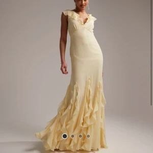 Ljusgul balklänning med volanger - HELT SLUTSÅLD, OANVÄND MED LAPP KVAR! Elegant ljusgul balklänning med volanger och v-ringad design. Klänningen har korta ärmar och en vacker volangdetalj som ger en romantisk känsla. Perfekt för speciella tillfällen. 💕💕💕fråga om fler bilder