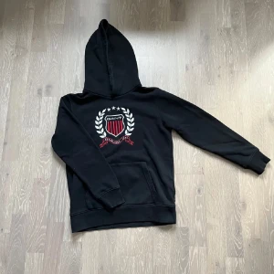 Svart hoodie från gant - Säljer en svart hoodie från GANT med ett snyggt broderat emblem på bröstet | Skick 9/10 | Storlek 158/164 | Vid frågor eller funderingar är det bara att höra av sig! Priset är inte hugget🍾