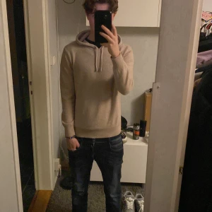 Kashmir hoodie - Säljer en stilren beige hoodie från sayless i mjukt kashmir. Tröjan har långa ärmar och en klassisk huva med snörning. Perfekt för en avslappnad och bekväm stil. Börjar bli för liten för mig,är 171