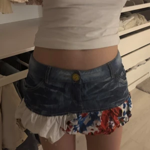 Jeanskjol med blommigt mönster - Fin jeanskjol med blommig volang🌸en defekt som inte syns när man har på sig men så man är medveten!(be mig skicka bild privat om det behövs) skicka egna prisförslag❣️