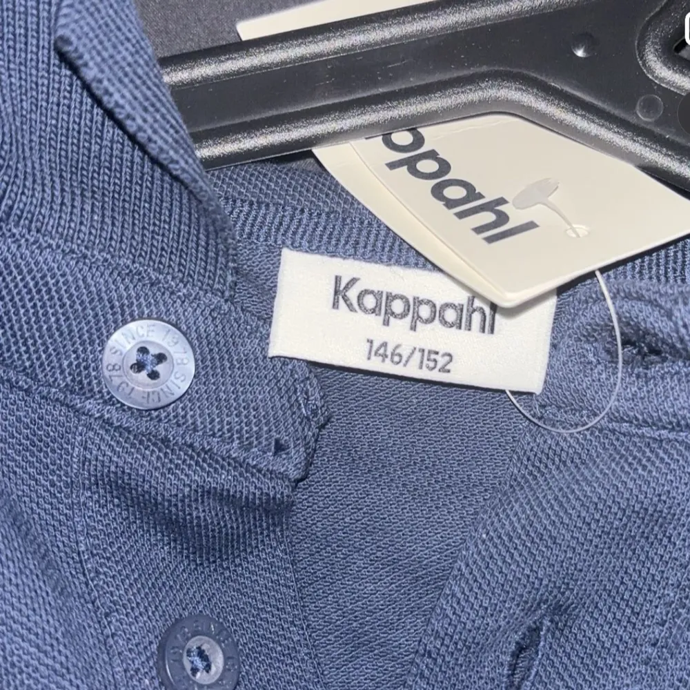 Säljer en stilren mörkblå pikétröja från Kappahl. Tröjan har korta ärmar och klassisk krage med knappar framtill. Perfekt för en avslappnad och snygg look. . T-paidat.