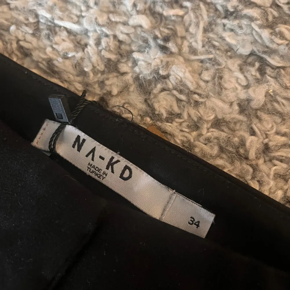 Snygga svarta kostymbyxor från NA-KD i storlek 34. Byxorna har en klassisk design med hög midja och raka ben. Perfekta för en stilren look.. Farkut & Housut.