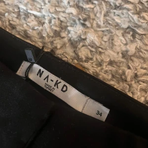 Svarta kostymbyxor från NA-KD - Snygga svarta kostymbyxor från NA-KD i storlek 34. Byxorna har en klassisk design med hög midja och raka ben. Perfekta för en stilren look.