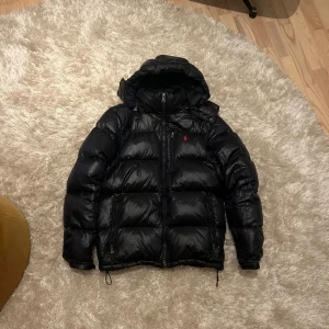 Ralph Lauren jacka - Säljer nu denna extremt snygga dunjackan från Ralph Lauren i marinblå. Jackan är i storlek M och  är i princip i nyskick utan några defekter. Om du söker en snygg jacka som funkar för vår, höst och vinter så är denna helt perfekt för dig!